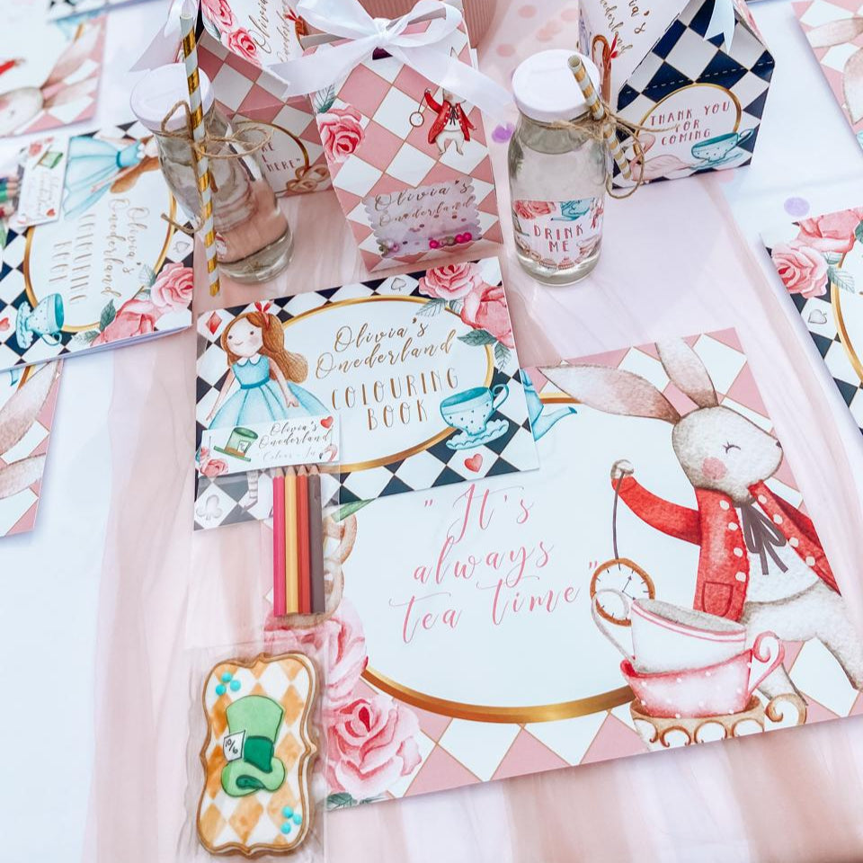 Decorative items including a teapot, cookies, and floral arrangement on a checkered tablecloth.