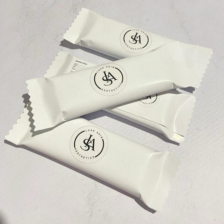 Four white chcocolate bars with a logo on a light gray background
